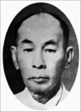 Phraya Manopakorn Nititada, born Kon Hutasingha (July 15, 1884–October 1, 1948) was the first Prime Minister of Siam after the Siamese Revolution of 1932. He was selected by the leader of the People's Party - the party that instigated the revolution. However, in the following year, 1933,  Manoparkorn was ousted by a coup due to conflicts between members of the People's Party.<br/><br/>

The coup d'état happened on 20 June, led by Phraya Pahol and other military leaders. Phraya Manopakorn was immediately removed as Prime Minister. Phraya Phahol appointed himself the country's second Prime Minister and took over the Government, King Pradhipok (Rama VII) duly accepted his appointment. Manopakorn was then exiled to Penang, British Malaya, by train and spent the rest of his life there until his death in 1948, aged 64.